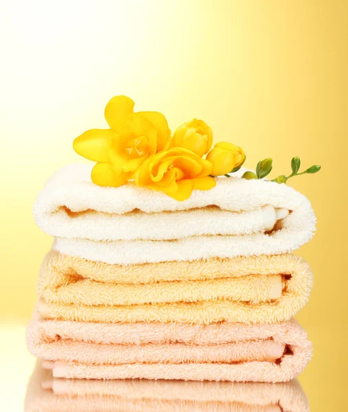 多彩毛巾和黄色背景上的花朵 — 图库照片