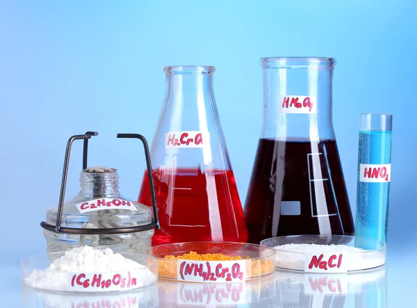 Tubos de ensaio com vários ácidos e produtos químicos sobre fundo violeta — Fotografia de Stock