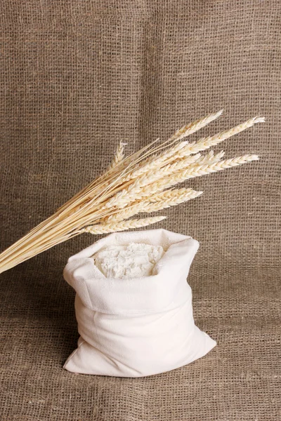 Farinha e grão de trigo sobre pano de saco — Fotografia de Stock