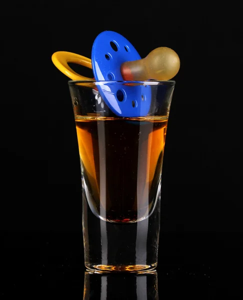 Baby dummy with alcoholic beverage isolated on black — Stock Photo, Image