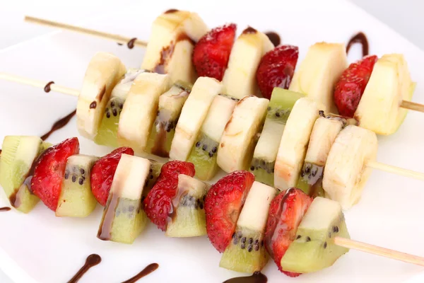 Mixed fruits and berries on skewers with chocolate close-up — Stock Photo, Image