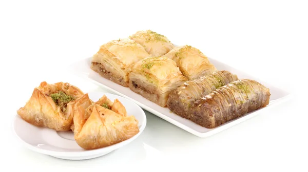 Sweet baklava on plates isolated on white — Stockfoto