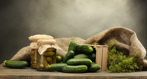 新鲜黄瓜在木盒、 泡菜和莳萝，灰色的背景上 — 图库照片