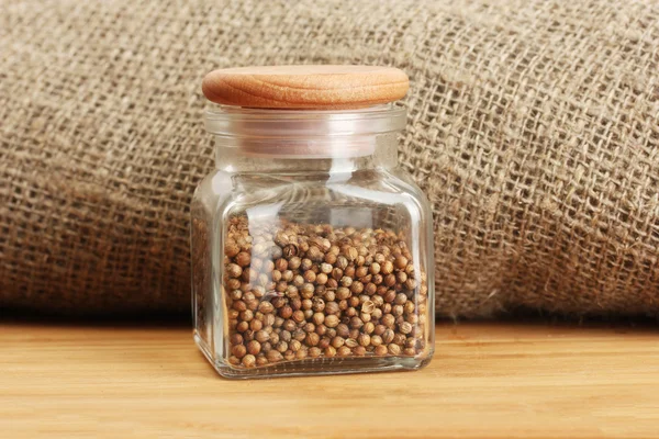 Jar of coriander seeds on canvas background close-up — Stock Photo, Image