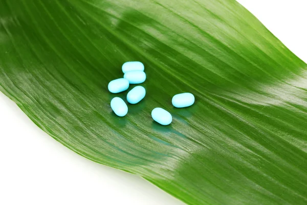 Comprimidos em folha verde isolados em branco — Fotografia de Stock