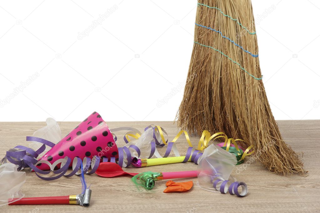 Broom sweep the trash after a party on white background close-up