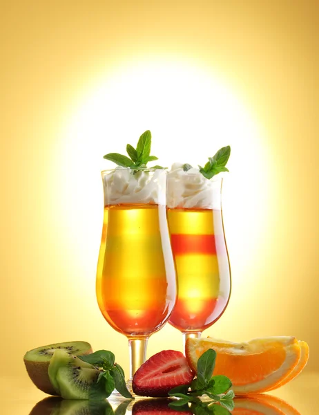Fruchtgelee in Gläsern und Früchten auf gelbem Hintergrund — Stockfoto