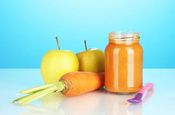 Frasco com frutas e legumes comida de bebê e colher no fundo colorido — Fotografia de Stock