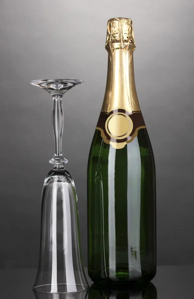 Bir şişe şampanya ve gri arka plan üzerinde kadehi — Stok fotoğraf