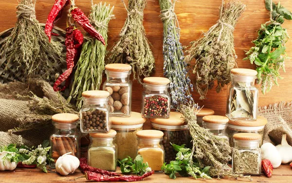 Gedroogde kruiden, specerijen en en peper, op houten achtergrond — Stockfoto