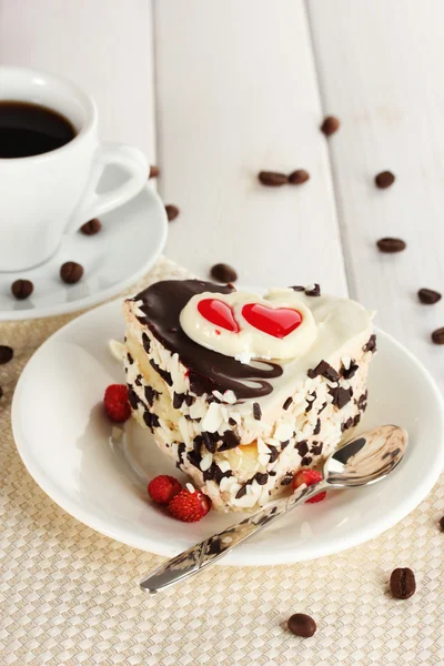 Zoete cake met chocolade op plaat en kopje koffie op houten tafel — Stockfoto