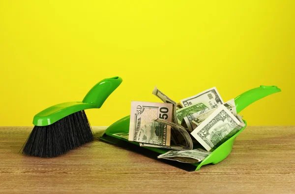 Sweeps money in the shovel on colorful background close-up — Stock Photo, Image