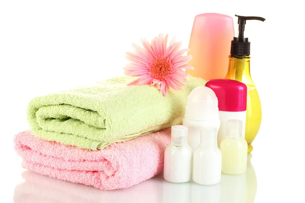 Bottiglie di cosmetici con asciugamani e fiori isolati su bianco — Foto Stock