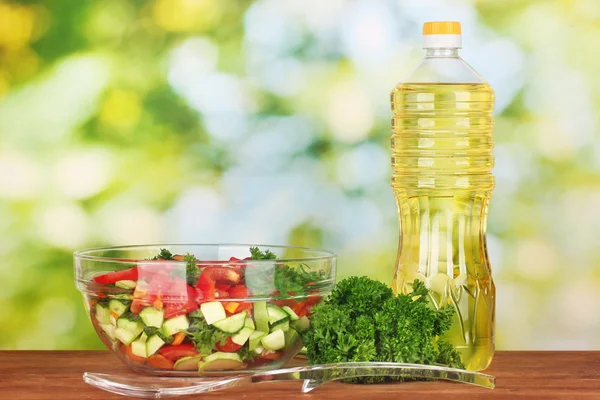 Čerstvý salát a olej na zeleném pozadí — Stock fotografie