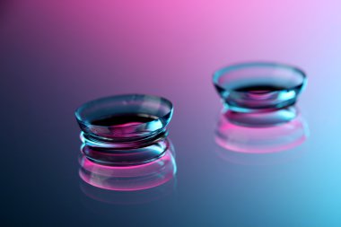 Contact lenses, on pink-blue background clipart