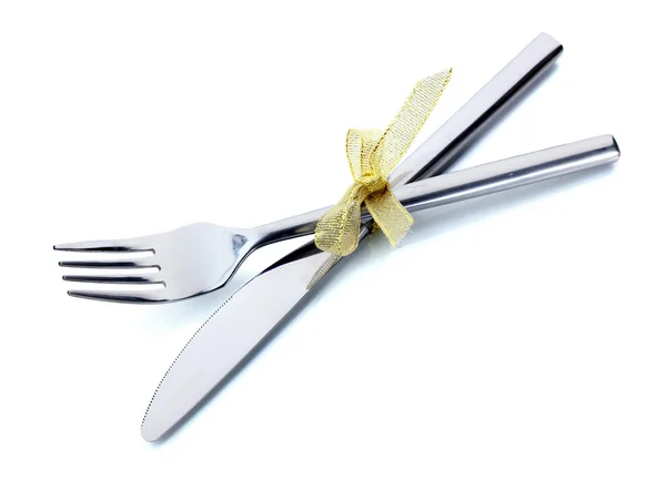 Серебряная вилка и нож, завязанные лентой, изолированные на белом — стоковое фото