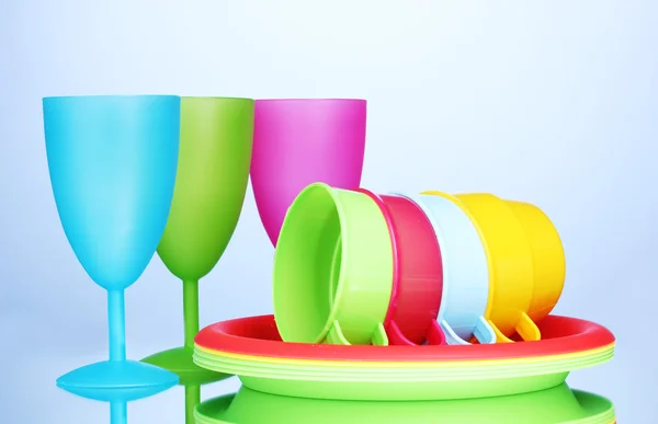 Яркая пластиковая посуда на синем фоне — стоковое фото