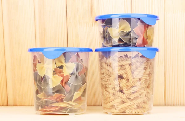 Filled plastic containers on wooden background — Stock Photo, Image