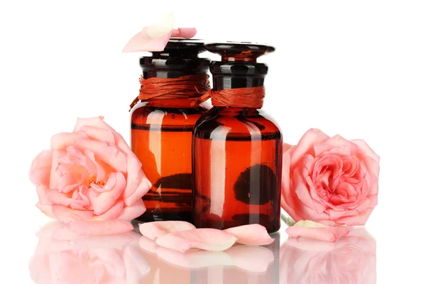Flaskor olja och isolerad på vita rosor — Stockfoto