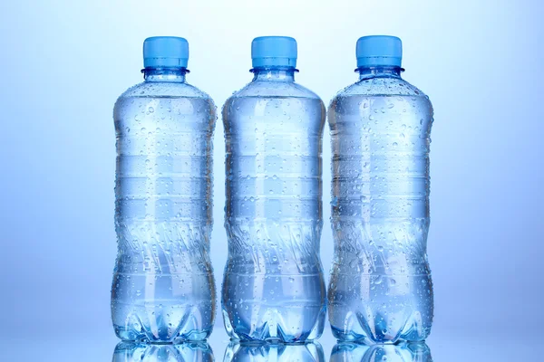 Műanyag palack víz a kék háttér — Stock Fotó