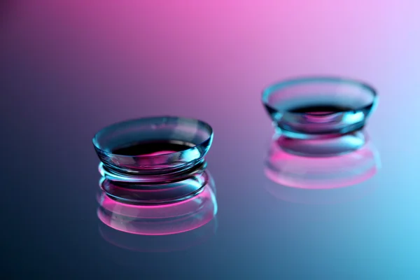 Kontaktlinsen, auf rosa-blauem Hintergrund — Stockfoto