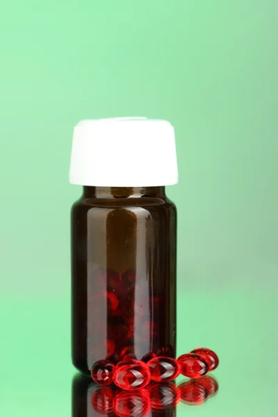 Jar de pílulas em fundo verde close-up — Fotografia de Stock