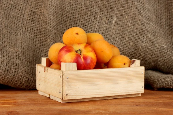 Reife Früchte in Holzkiste auf Leinwand Hintergrund Nahaufnahme — Stockfoto