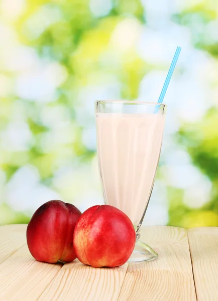 Peach milk shake on wooden table on bright background — Stock Photo, Image