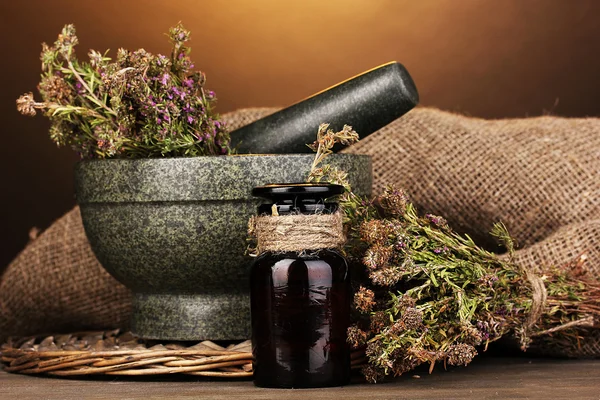Thyme herb and mortar on wooden table on brown background — Stock Photo, Image