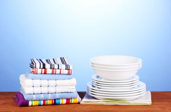 Toalhas de cozinha com pratos em fundo azul close-up — Fotografia de Stock