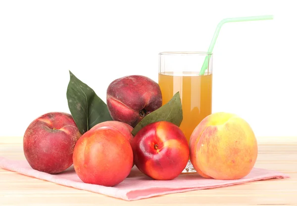 Mogna persikor och juice på träbord på vit bakgrund — Stockfoto