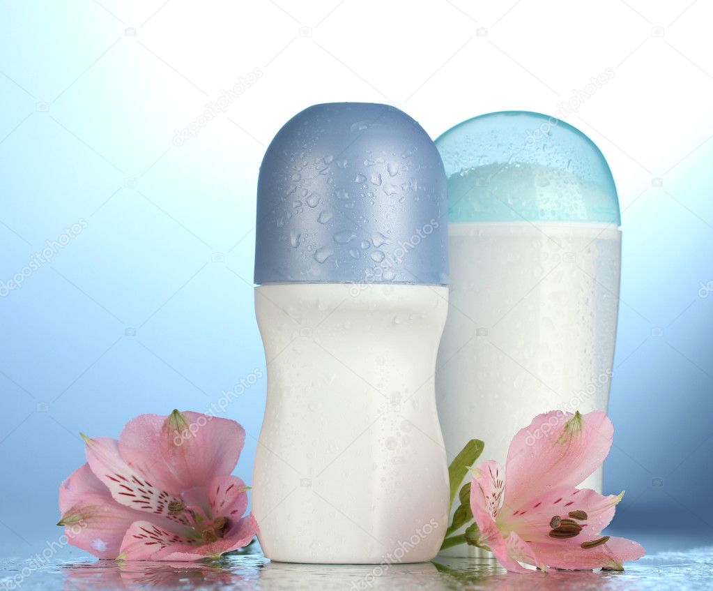 Deodorants with flowers on blue background