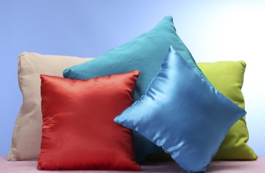 Bright pillows on blue background clipart