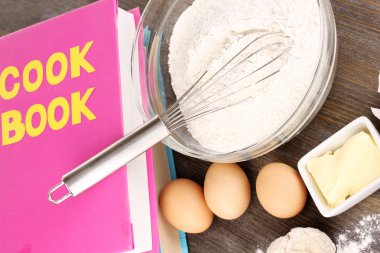 Eggs, flour and butter close-up on wooden table clipart