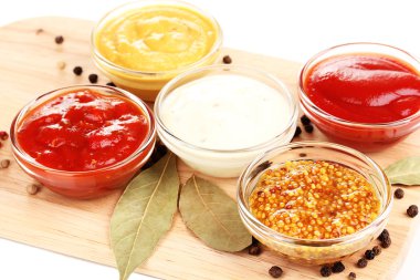 Various sauces on chopping board close-up clipart