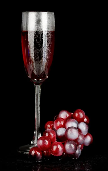 Een glas wijn en druiven geïsoleerd op zwarte backgrund close-up — Stockfoto