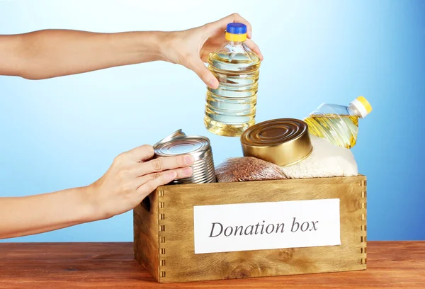 捐款箱与上蓝色背景特写的食物 — 图库照片
