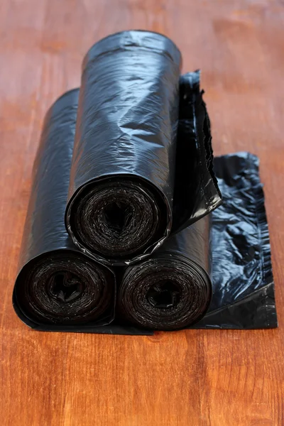 Plastic garbage bags on wooden background close-up — Stock Photo, Image