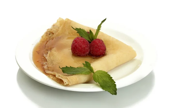 Вкусный блин с ягодами и медом на тарелке на деревянном столе — стоковое фото