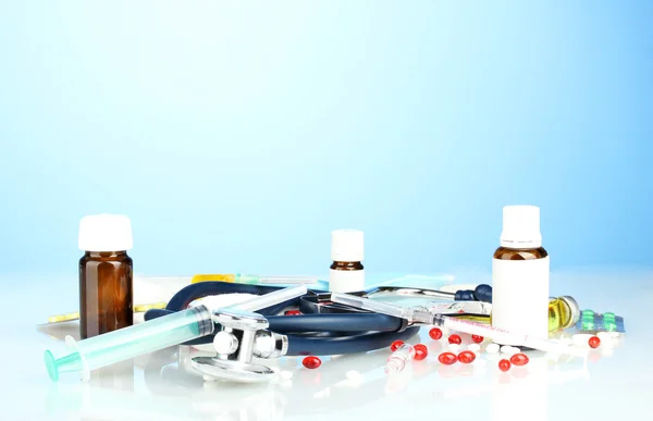 Léky a stetoskop na modrém pozadí detail — Stock fotografie