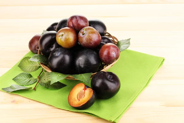 stock image Rip plums on basket on wooden table