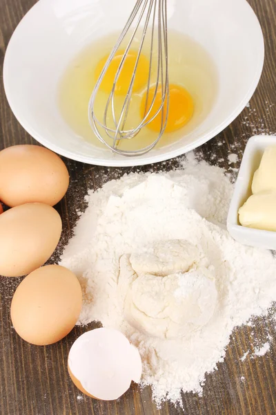 Яйця, борошно і масло крупним планом на дерев'яному столі — стокове фото