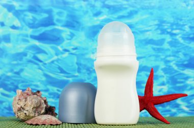 deodorant, fishstar ve kabukları mavi deniz arka plan üzerinde