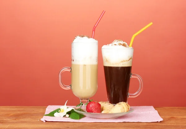 Copos de coquetel de café no guardanapo colorido com croissants e flor no fundo brilhante — Fotografia de Stock