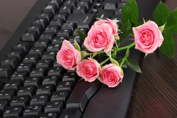 粉红色玫瑰上键盘特写的互联网通信 — 图库照片
