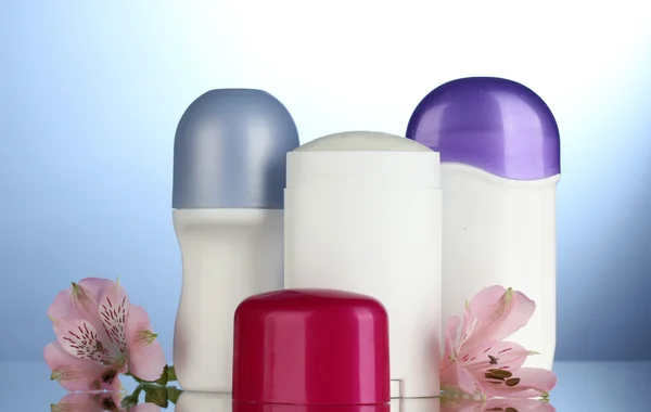 Mavi zemin üzerine çiçekli deodorantlar — Stok fotoğraf