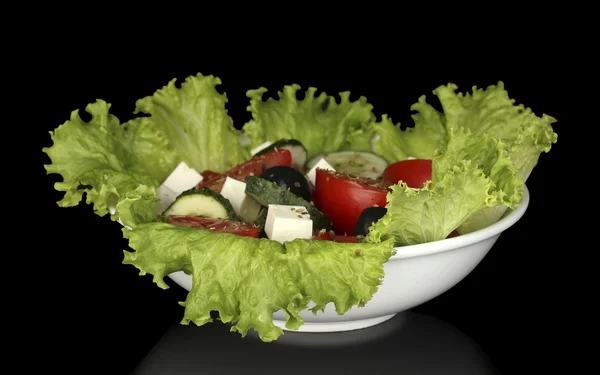 Leckerer griechischer Salat isoliert auf schwarz — Stockfoto