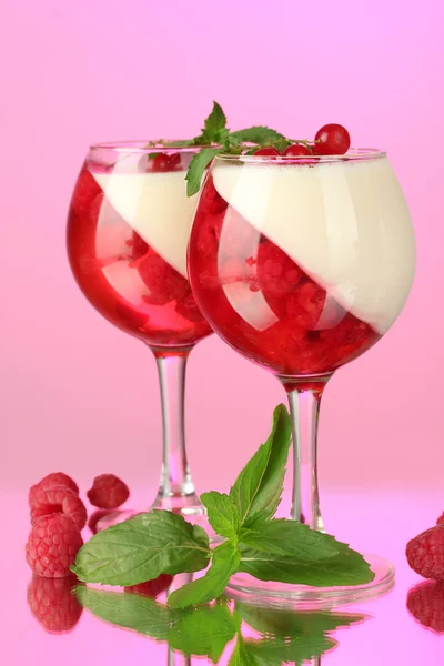 Fruit gelei met bessen in bril op roze achtergrond — Stockfoto