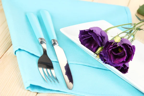 Посуда с цветами на яркой салфетке крупным планом — стоковое фото