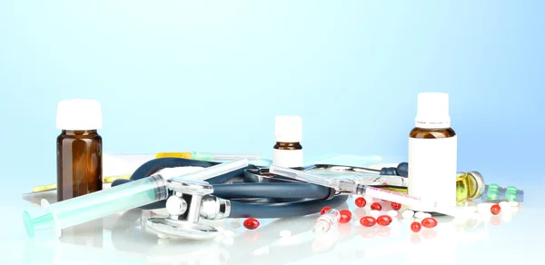 Medicines and a stethoscope on a blue background close-up — Stock Photo, Image